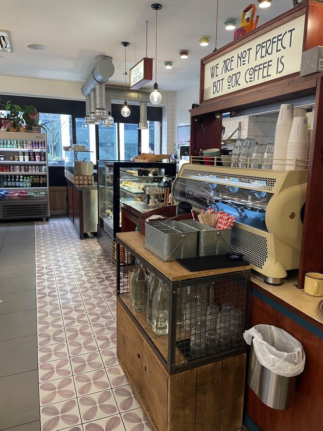 The counter and chilled display cabinet with drinks fridge and coffee grinders.