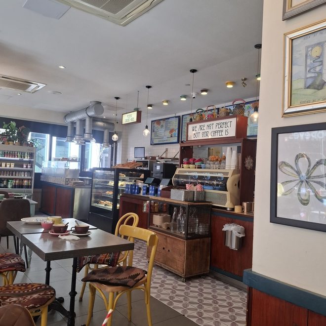 The room looking towards the counter, framed pictures and tiled floor.
