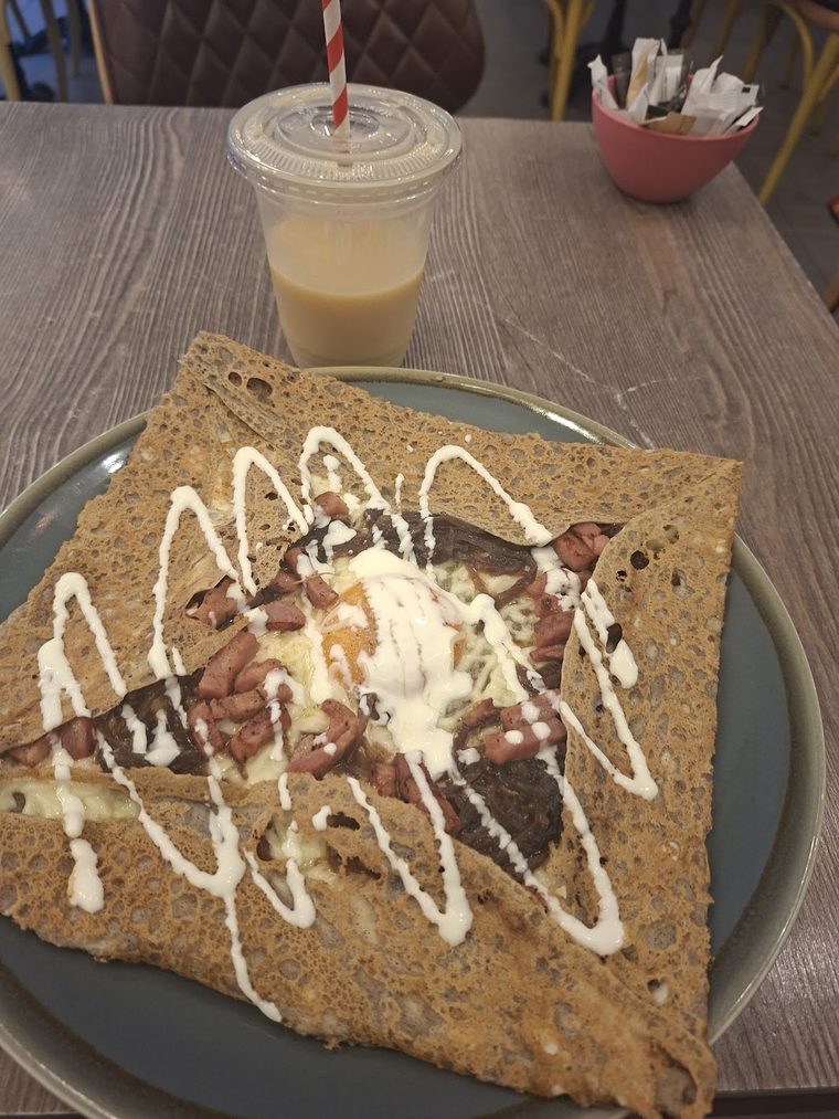 Buckwheat crêpe with white chocolate and nuts, with an iced coffee.